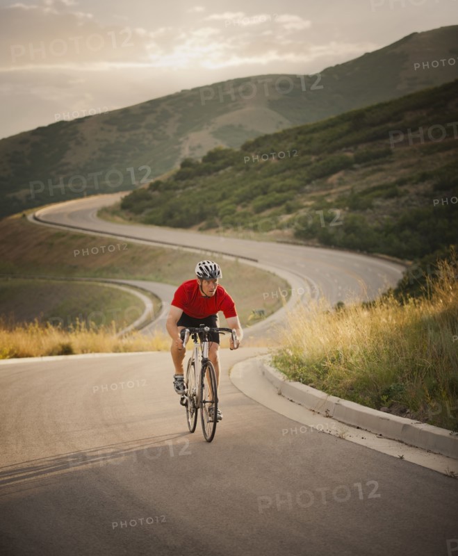 Caucasian man riding bicycle on remote road