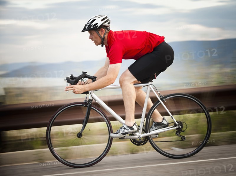 Caucasian man riding bicycle on remote road