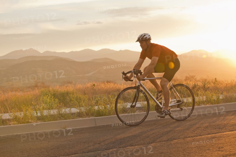 Caucasian man riding bicycle on remote road