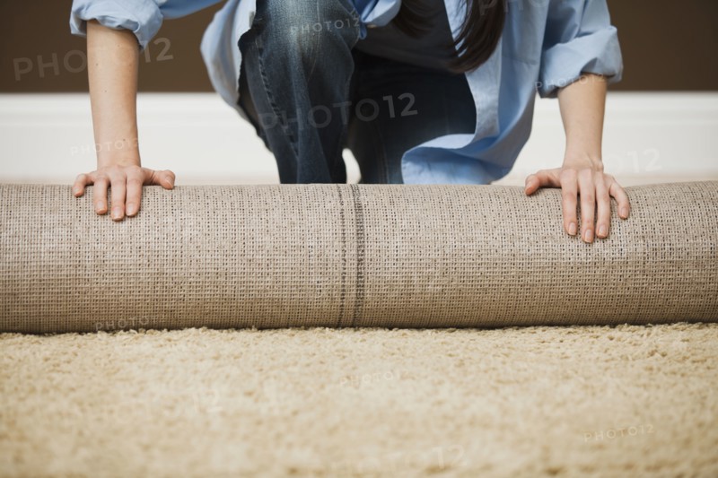 Caucasian woman unrolling carpet