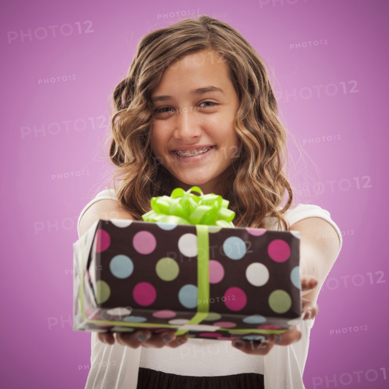 Caucasian teenager holding out gift