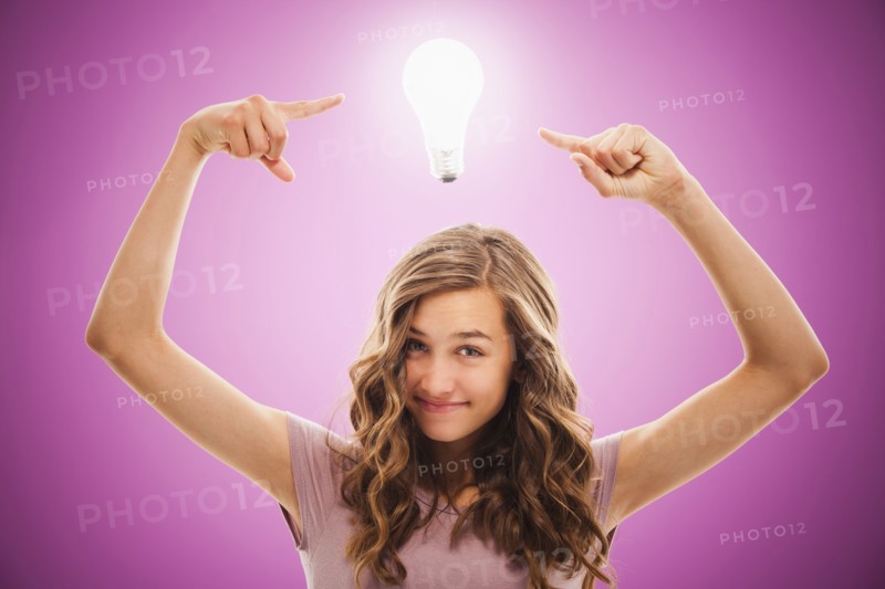 Caucasian teenager pointing at light bulb over her head