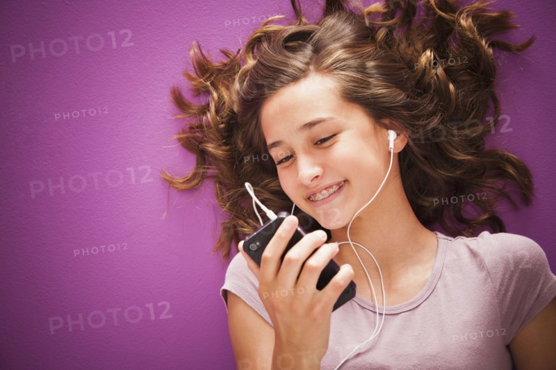 Caucasian teenager listening to music on mp3 player