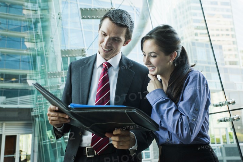 Caucasian business people looking at notebook together