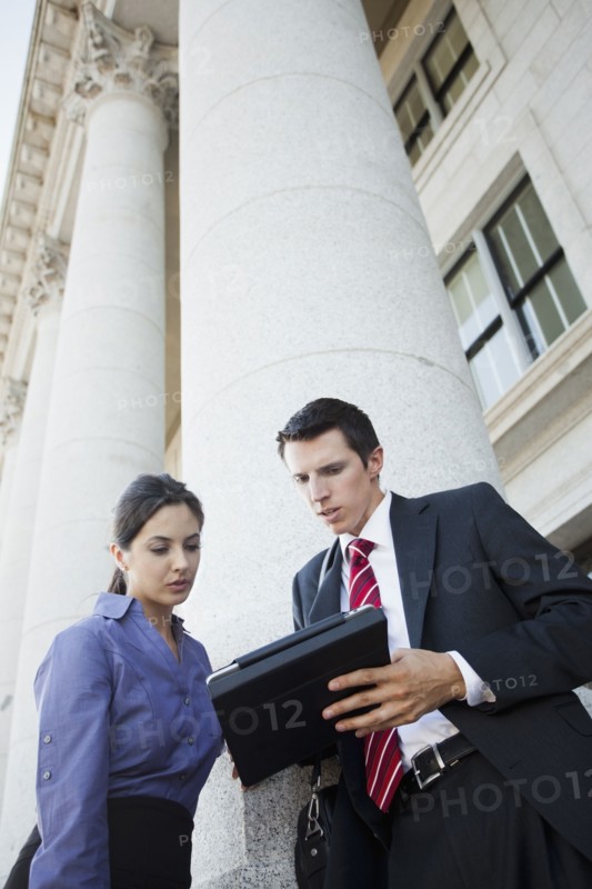 Caucasian business people looking at digital tablet