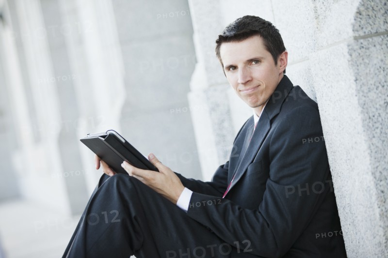 Caucasian businessman using digital tablet outdoors