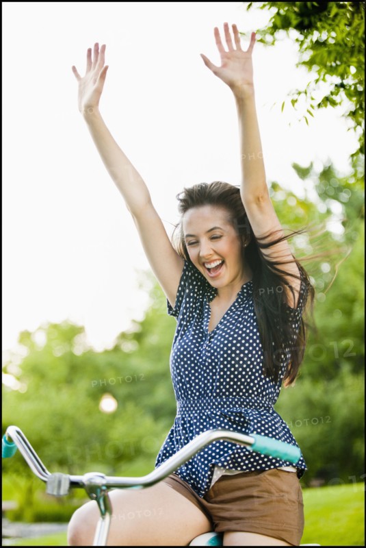 Cheering Caucasian woman cheering on bicycle