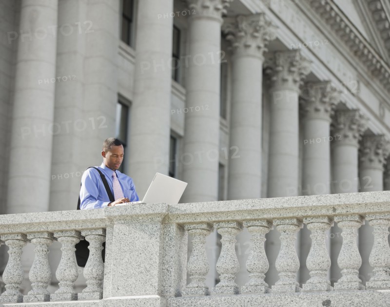 Black businessman using laptop outdoors