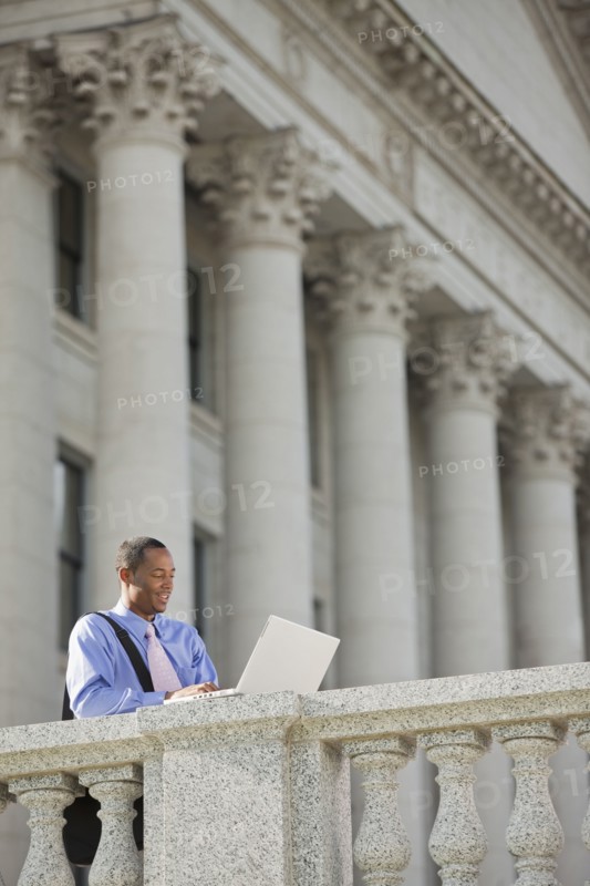 Black businessman using laptop outdoors