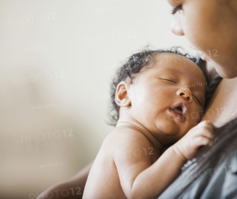 Mixed race mother holding newborn baby