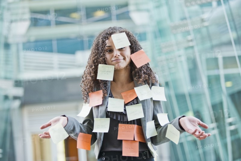 Caucasian businesswoman covered in sticky notes