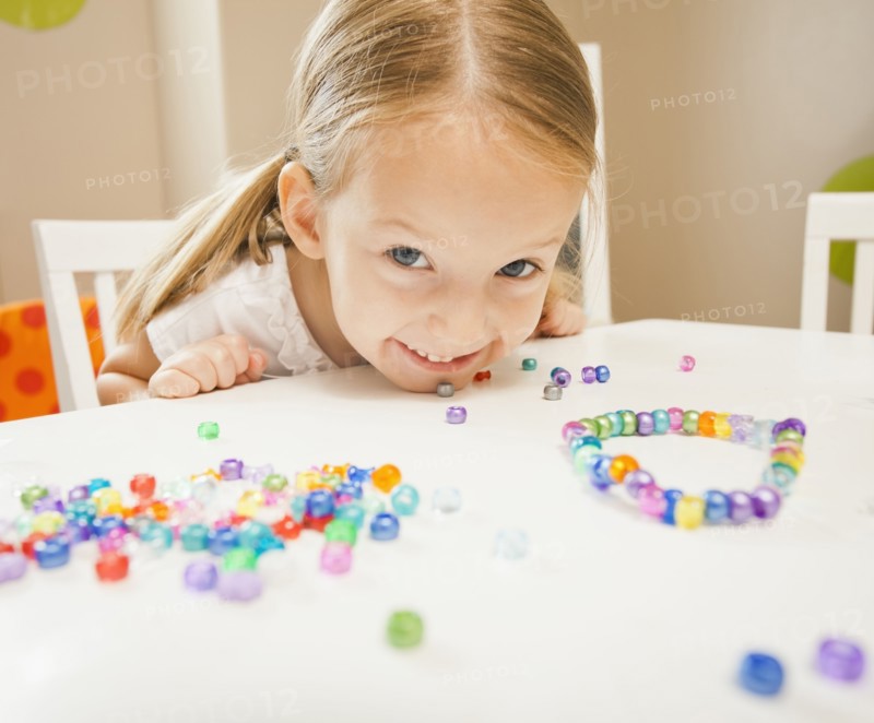 Caucasian girl stringing beads