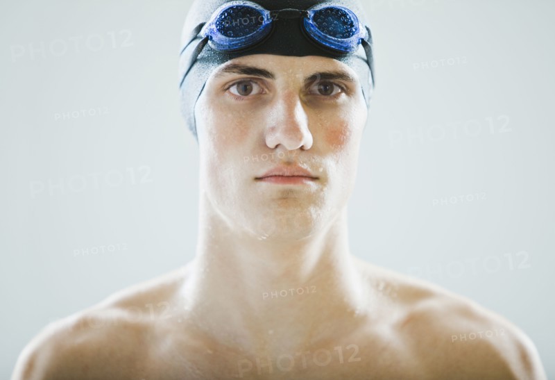 Caucasian teenage boy in swim cap and goggles