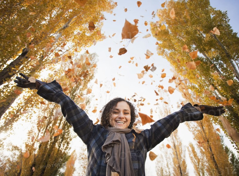 Caucasian woman playing with autumn leaves