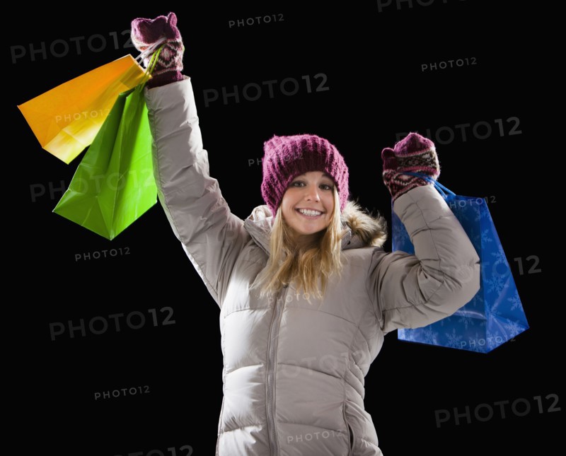 Caucasian woman in coat holding shopping bags