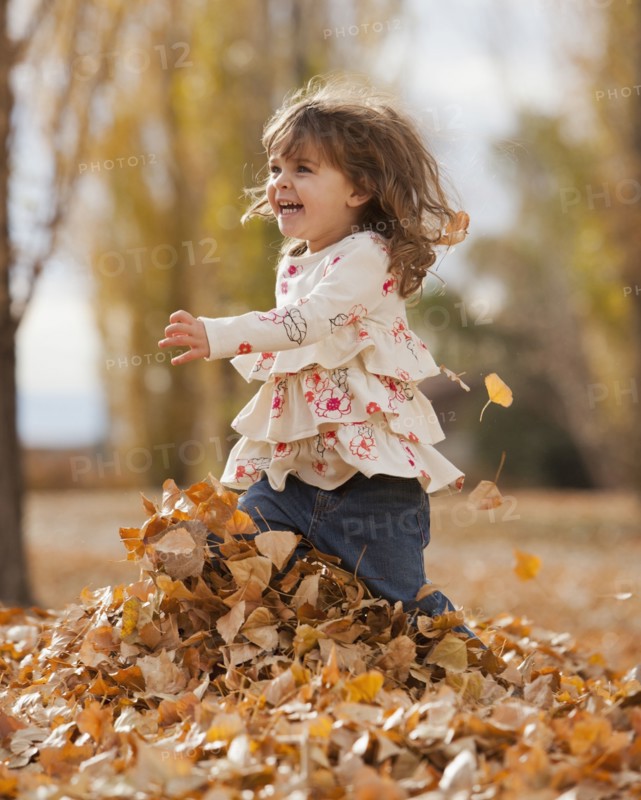 Caucasian girl playing in autumn leaves