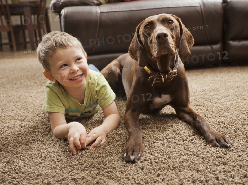 Caucasian boy sitting on floor with dog