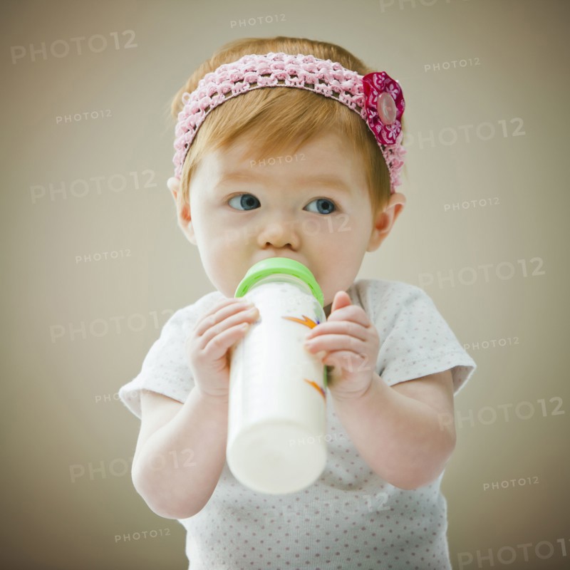 Caucasian baby girl drinking bottle