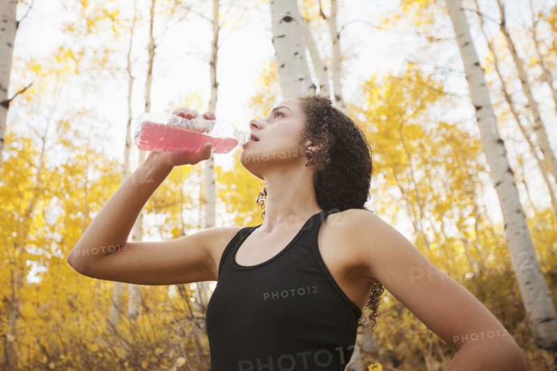 Caucasian woman drinking juice after exercise