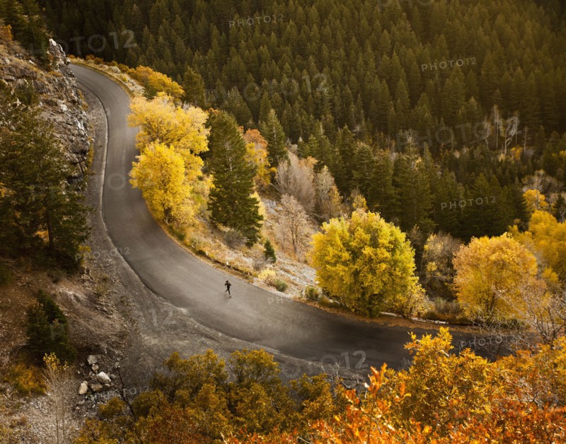 Caucasian woman running along autumn road