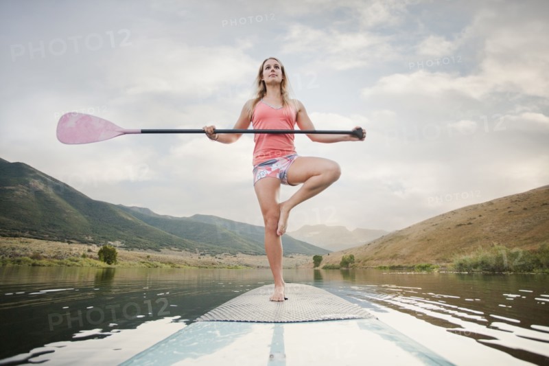 Caucasian woman on stand up paddle board