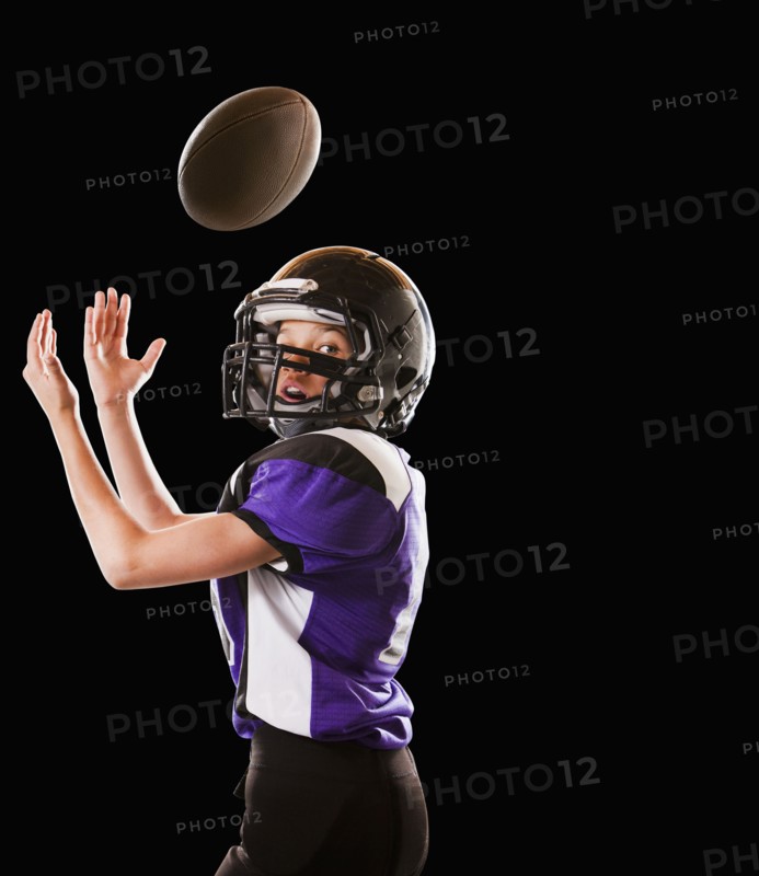 Mixed race football player catching football