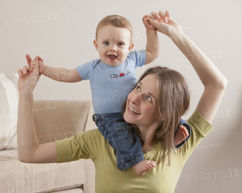 Caucasian mother carrying son on her shoulders