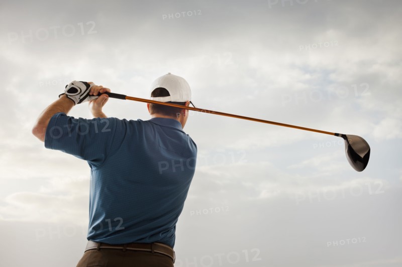 Caucasian golfer swinging golf club