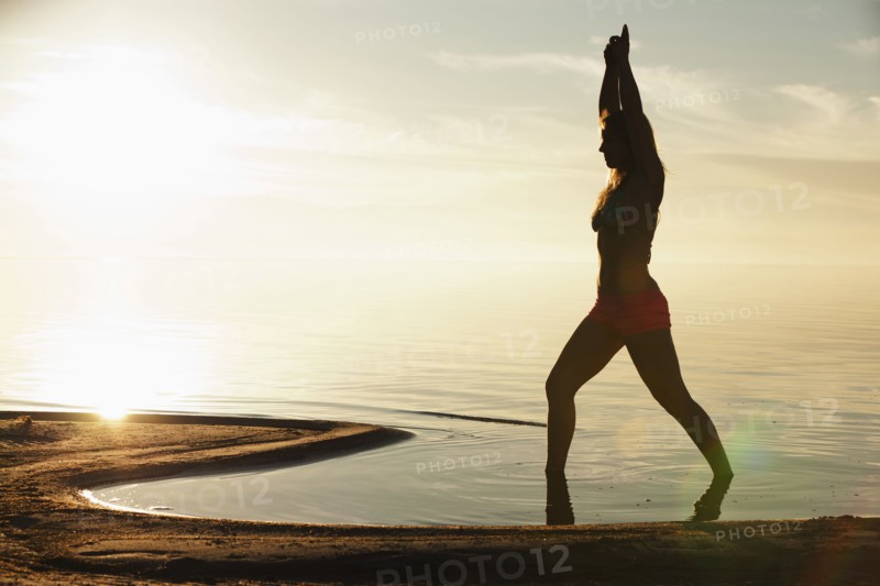 Caucasian woman practicing yoga on beach