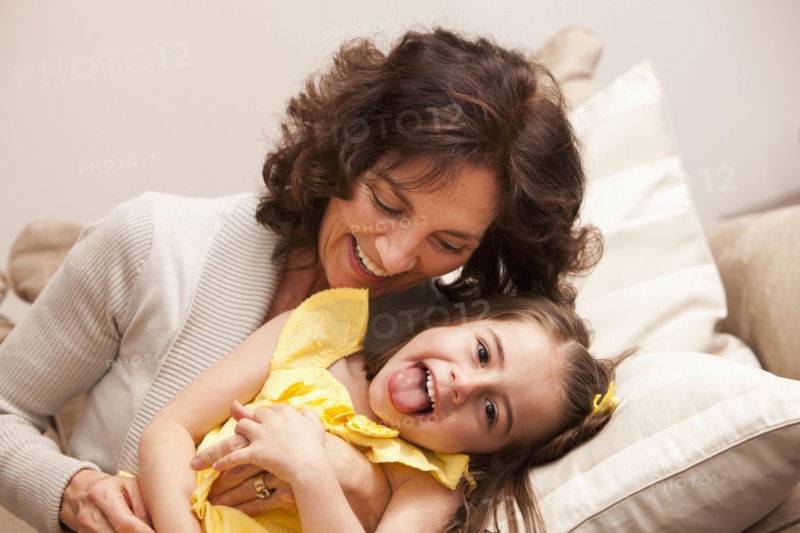 Caucasian grandmother tickling granddaughter