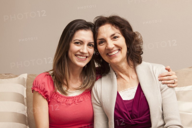 Caucasian mother and daughter sitting on sofa