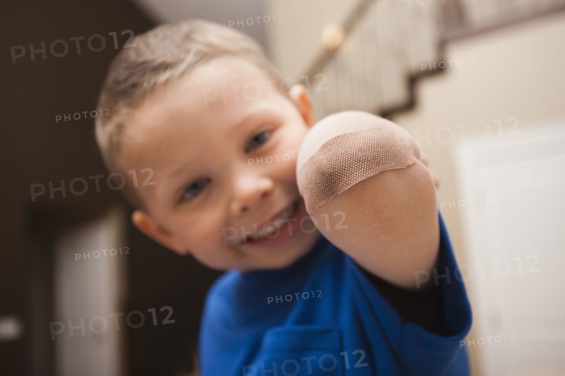 Caucasian boy with bandage on elbow
