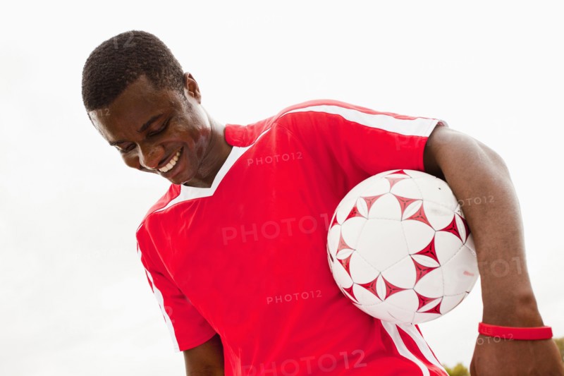 Black soccer player holding ball