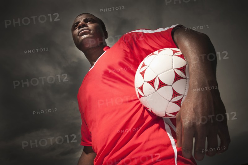 Black soccer player holding ball