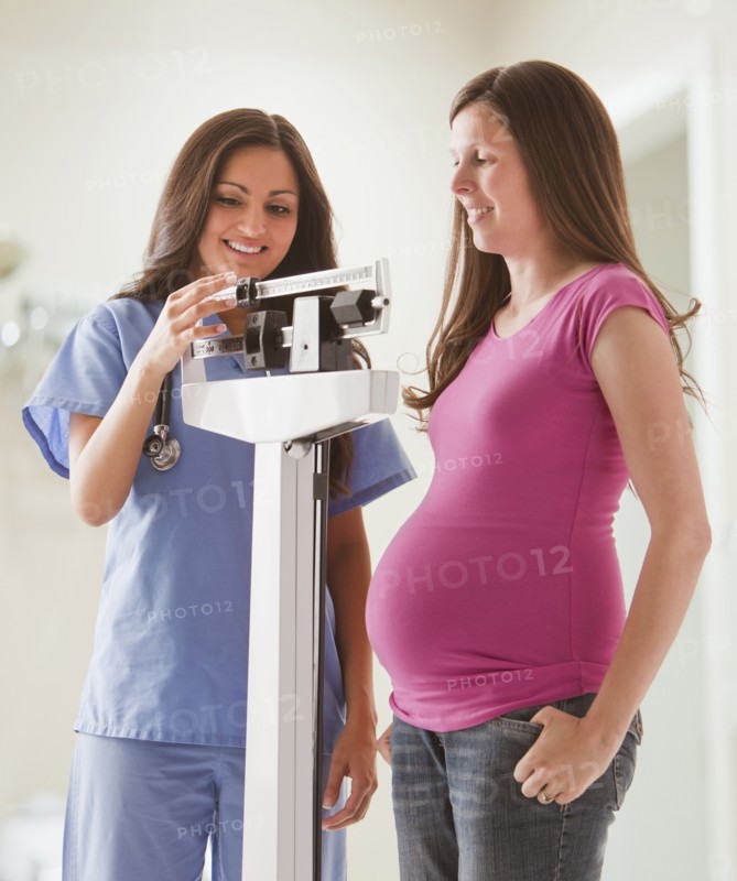 Nurse weighing pregnant woman