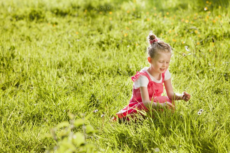 Caucasian girl picking flowers in field