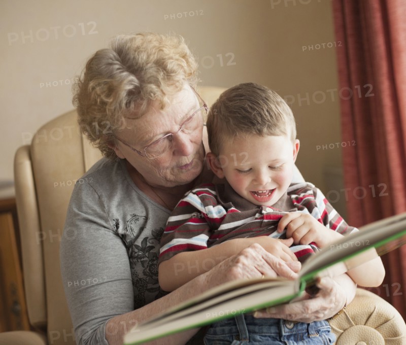 Caucasian grandmother reading book to grandson