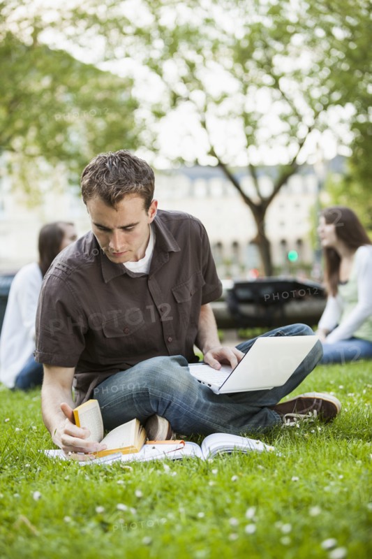 Caucasian man studying in grass