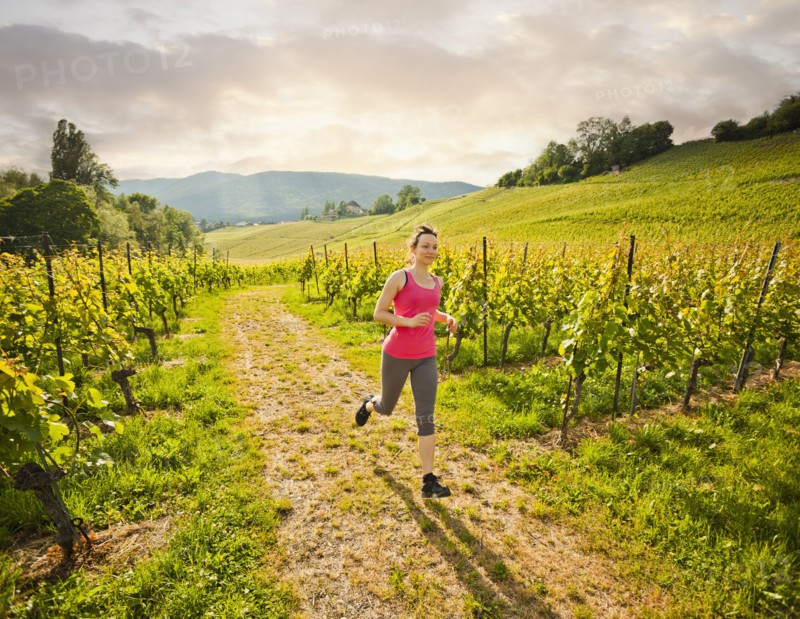Caucasian woman running in vineyard