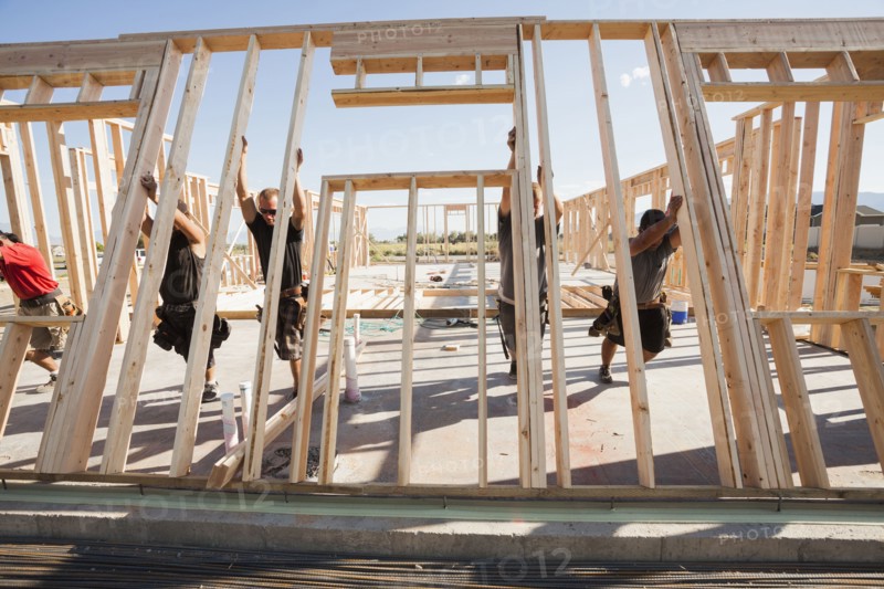 Workers lifting frame on construction site