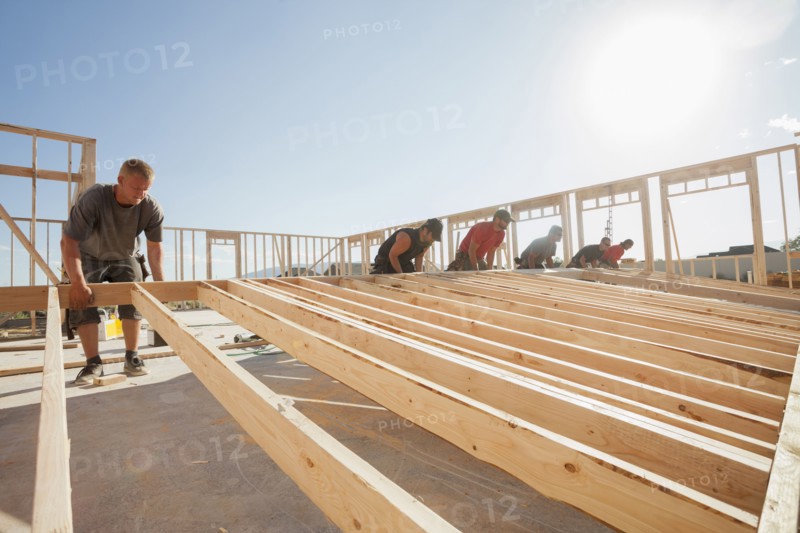 Workers lifting frame on construction site