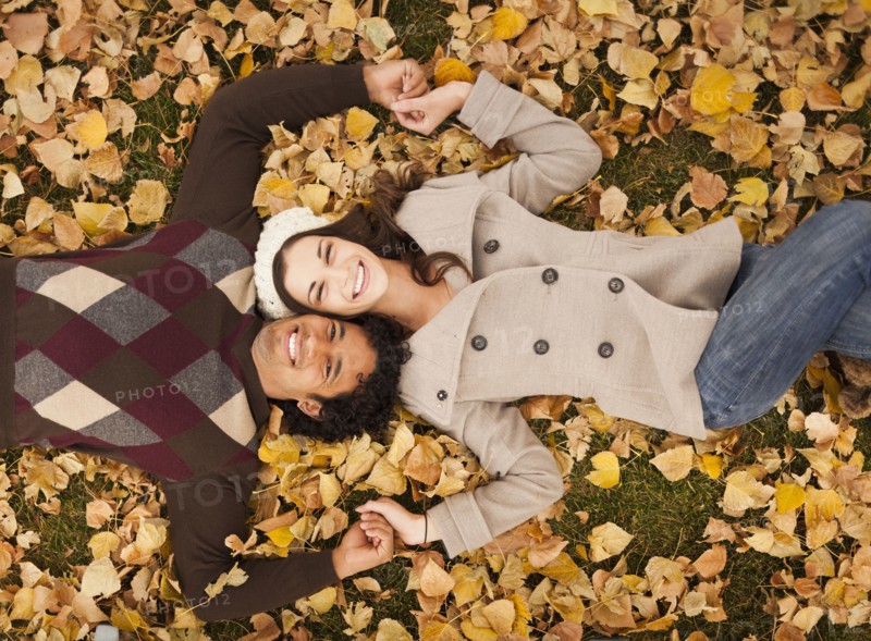 Couple laying in autumn leaves