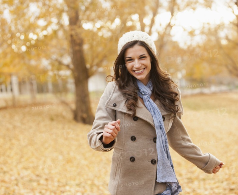 Caucasian woman walking in autumn leaves