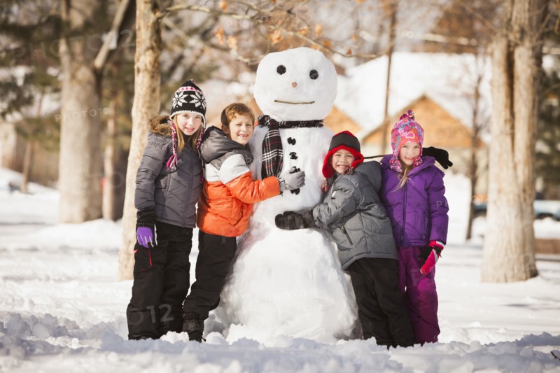 Caucasian family building snowman in snow