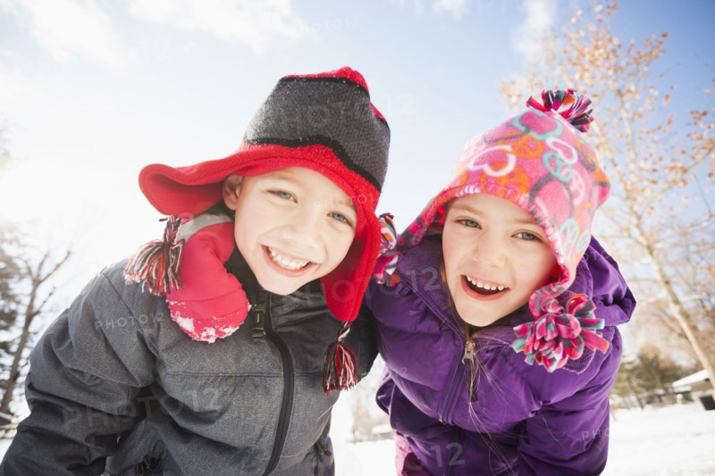 Caucasian children smiling in snow