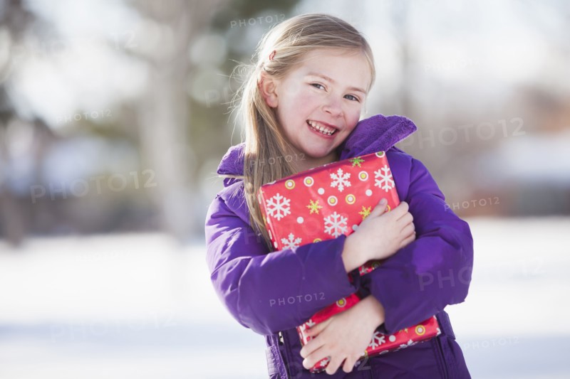 Caucasian girl holding Christmas present