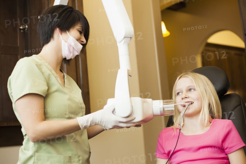 Technician making x-ray of girl's teeth
