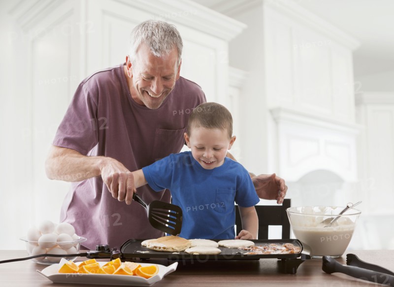 Caucasian father and son cooking breakfast