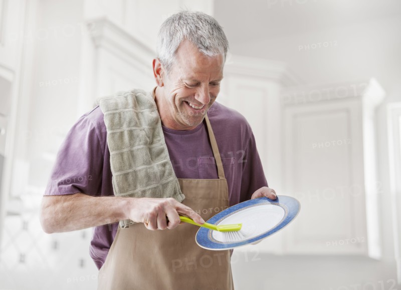 Caucasian man washing dishes in kitchen