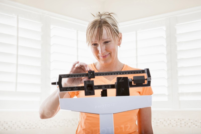 Caucasian woman weighing herself